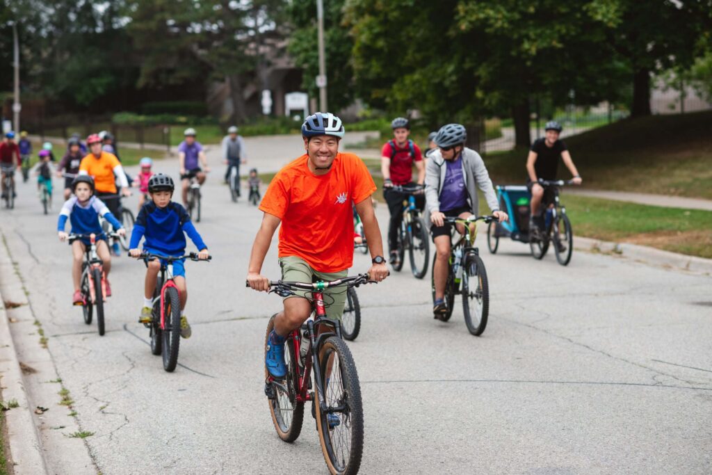 Group of adults and kids riding bikes together for Rolling Horse Community Cycle